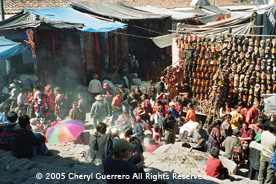 The huge indigenous market in Chichicastenango offers multitudinous textiles, wood carvings, maguey bags, incense, machetes and endless trinkets.  Photo by Cheryl Guerrero 2005.