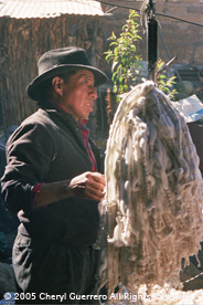 Lucas Pastor, owner of a dye workshop in Salcajá, weighs a bundle of bound jaspe or ikat thread prior to submersion into a boiling vat of dye.  Photo by Cheryl Guerrero 2005.