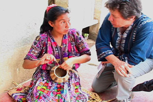 Juana Chopin Bocela weaves a pine needle basket while listening to Deborah Chandler, Director of Mayan Hands.  Photo by Kathleen Mossman Vitale 2005.