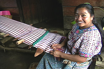 María Estela Chumil Sicajan weaves in the shade outside her home in San Lucas Tolimán.  The huipil she wears has tiny designs of ducks, birds and dogs, and is the traditional style in her community.   Photo by Kathleen Mossman Vitale 2004.